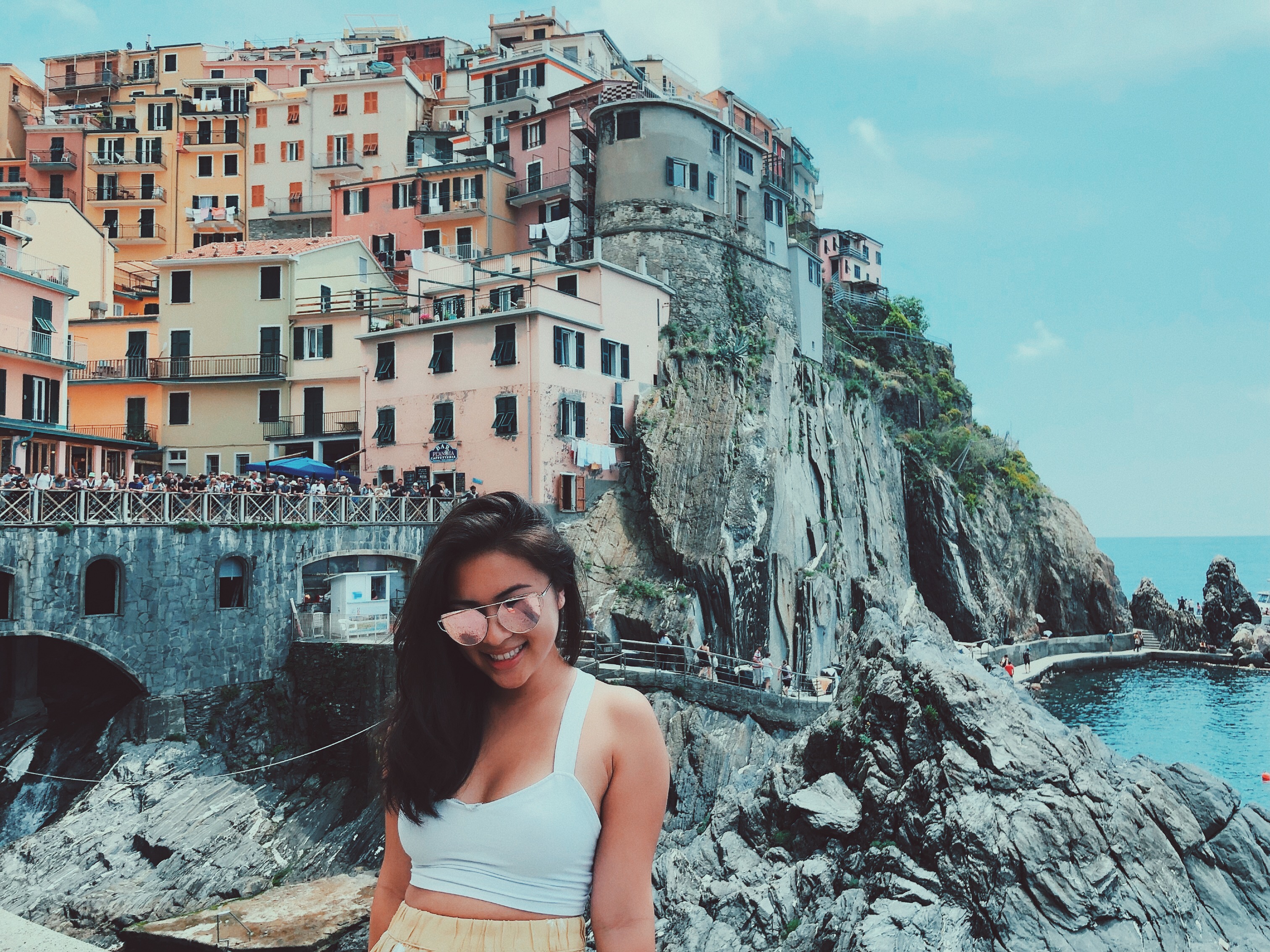 smiling in front of cinque terre lanscape manarola village