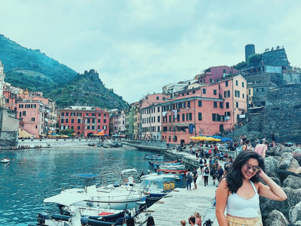 travel blogger ang around the globe in front of vernazza cinque terre landscape